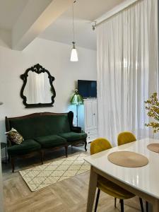 Una sala de estar con un sofá verde y una mesa. en Parrot Chic Apartment, en Bar