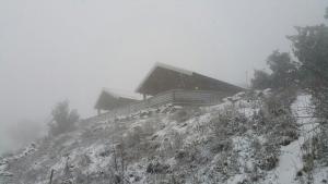 dom na szczycie śnieżnej góry w obiekcie Gilad Cabins w mieście Odem