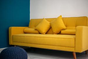 ein gelbes Sofa mit gelben Kissen in einem Zimmer in der Unterkunft Perfect resort style House in Playa del Carmen