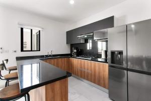 eine Küche mit schwarzen und hölzernen Schränken und einer Mikrowelle in der Unterkunft Perfect resort style House in Playa del Carmen