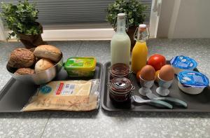 a tray of food with eggs bread and bottles of milk at B&B de Vaert in Kaatsheuvel +4 photos