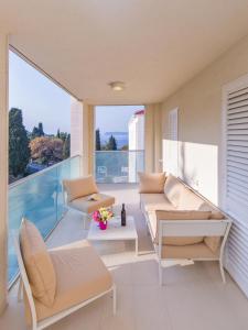 d'un salon avec un canapé et des chaises sur un balcon. dans l'établissement Dubrovnik Luxury Residence – L’Orangerie, à Dubrovnik