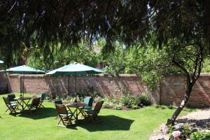 a group of tables and chairs with umbrellas in a yard at St Margaret's Hotel in Oxford