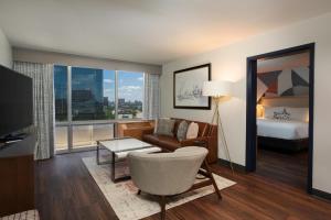 a living room with a bed and a living room with a couch at The Beeman Hotel in Dallas
