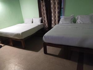 two beds sitting next to each other in a room at Deep view luxury villa Coffee Cottage Coorg in Madikeri