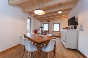 a kitchen and dining room with a wooden table and chairs at Ciesa dela Maestra in Rocca Pietore +38 photos