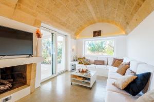 een woonkamer met een witte bank en een open haard bij KYVOS 10, Emma Villas in Marina di Leuca