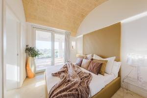 een slaapkamer met een groot bed en een raam bij KYVOS 10, Emma Villas in Marina di Leuca +45 foto's