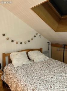 a bedroom with a bed with two pillows at Le Duplex de Léa in Valenciennes