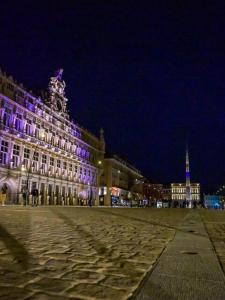 a large building with purple lights on it at night at Le Duplex de Léa in Valenciennes