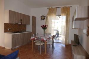 a kitchen and dining room with a table and chairs at Parco Meridiana in Scalea