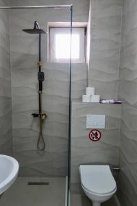 ein Badezimmer mit Dusche, Toilette und Waschbecken in der Unterkunft Green Apartment in Pristina