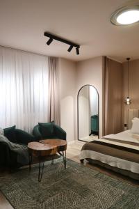 ein Schlafzimmer mit einem Bett, einer Couch und einem Tisch in der Unterkunft Green Apartment in Pristina