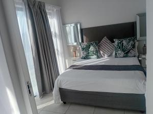 a bedroom with a large bed and a window at Penthouse Suite, Exquisite One Bedroom Apartment in Ballito +21 photos