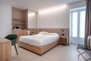 um quarto com uma cama, uma mesa e uma cadeira em Porta San Biagio - rooms & apartments em Matera
