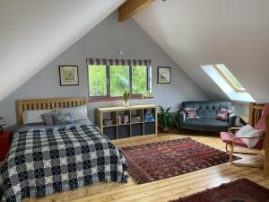 a bedroom with a bed and a couch in a attic at Dragon Orchard Retreat in Ledbury +12 photos