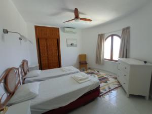 une chambre avec deux lits et un ventilateur de plafond dans l'établissement Villa Maravista - Luxury Villa with Private Pool and Sea View, à Benitachell 47 autres photos