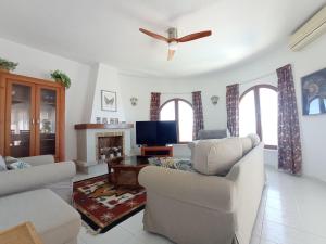 a living room with two couches and a tv at Villa Maravista - Luxury Villa with Private Pool and Sea View in Benitachell