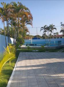 a courtyard with palm trees and a blue building at Casa com piscina in Porto Seguro +2 photos