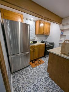 a kitchen with a stainless steel refrigerator and wooden cabinets at NewResidence in Niagara Falls