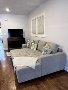 a living room with a couch and a flat screen tv at Charming 2-bedroom Cottage in San Antonio