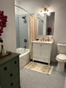 a bathroom with a sink and a toilet and a mirror at Charming 2-bedroom Cottage in San Antonio +33 photos
