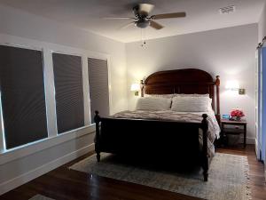a bedroom with a bed with a fan and windows at Charming 2-bedroom Cottage in San Antonio
