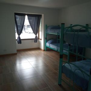 エル・カラファテにあるHostel Casa del Viajero 2の二段ベッドが2つと窓のある部屋