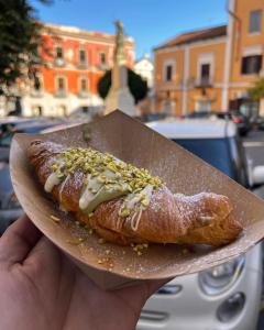 a person holding a plate with a pastry on it at B&B al Corso in Pagani