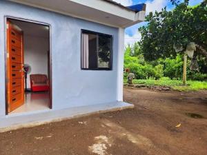 a white house with a red chair in the doorway at Villa Mendoza Residence B in San Jose