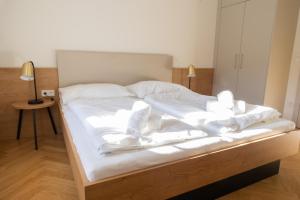 a bed with white sheets and pillows on it at Turmresidenz Färbergasse Graz in Graz
