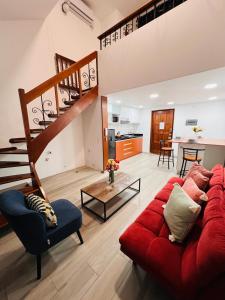 sala de estar con sofá rojo y escalera en MONTERRICO POLO APARTS #8 - Dpto de 2 camas Frente Embajada de USA con AC, en Lima