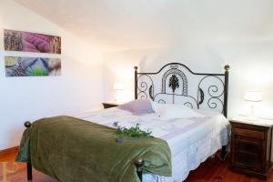 una camera da letto con un letto grande con una coperta verde di Window to the Valley a Santo Isidoro Altre 31 foto