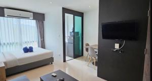 a hotel room with a bedroom with a bed and a tv at Condo near Central Phuket in Ban Ket Ho +8 photos