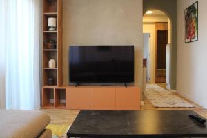 a living room with a flat screen tv on a cabinet at Sun Apartments in Pristina