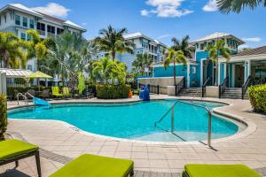 una piscina con palmeras y edificios en The Sunset Retreat at One Particular Harbour 384-202, en Bradenton