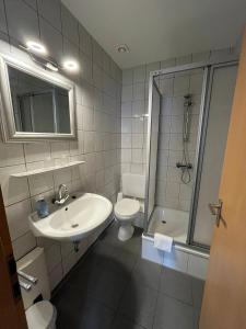 a bathroom with a sink and a toilet and a shower at Ferienwohnung am Liebesgrund in Lüneburg