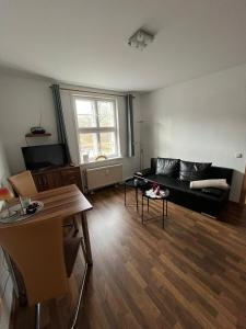 a living room with a black couch and a table at Ferienwohnung am Liebesgrund in Lüneburg