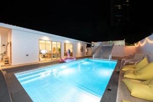 a large swimming pool in the middle of a house at De Beach pool villa เดิน 3 นาทีจากชายหาด in Jomtien Beach +45 photos