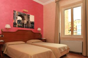 two beds in a room with red walls and a window at Hotel Kent in Rome