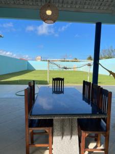 ein Tisch und Stühle mit Blick auf einen Tennisplatz in der Unterkunft Casa de praia No Abais in Praia Da Caueira