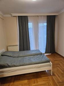 a bedroom with a bed in front of a window at Velike Šume Apartment in Pale