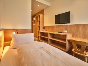 una camera d'albergo con un letto e una TV a schermo piatto di Pension Ehrenfried - Hotel garni a Kindberg