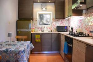 a small kitchen with a table and a stove top oven at Pear Tree Cottage in Lixouri