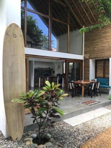 a wooden surfboard next to a house with a table at Casa Flora Ayampe in Ayampe