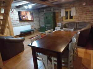 a dining room with a wooden table and chairs at Căsuța bunicii in Cavnic