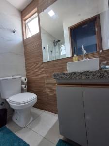 a bathroom with a toilet and a sink and a mirror at Flat Coqueiros 101 Praia in Tamandaré