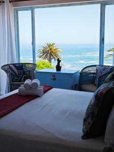 a bedroom with a bed with a view of the ocean at Beachwave Camps Bay in Cape Town