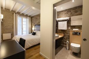 a bedroom with a bed and a bathroom with a sink at Hotel Montenegro Compostela in Santiago de Compostela