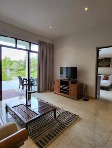 a living room with a tv and a couch and a table at Heavenly place in Surin Beach +9 photos